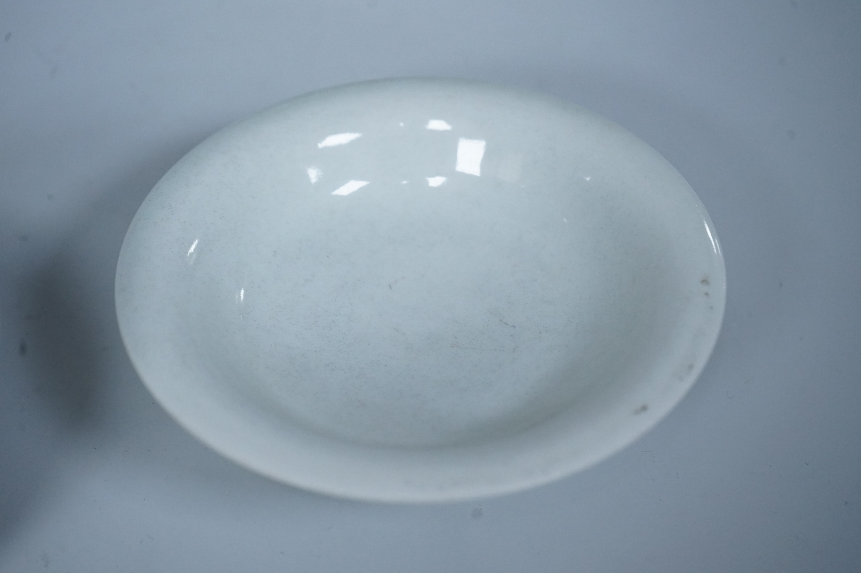 A Chinese white glazed stem cup and similar dish, tallest 7cm